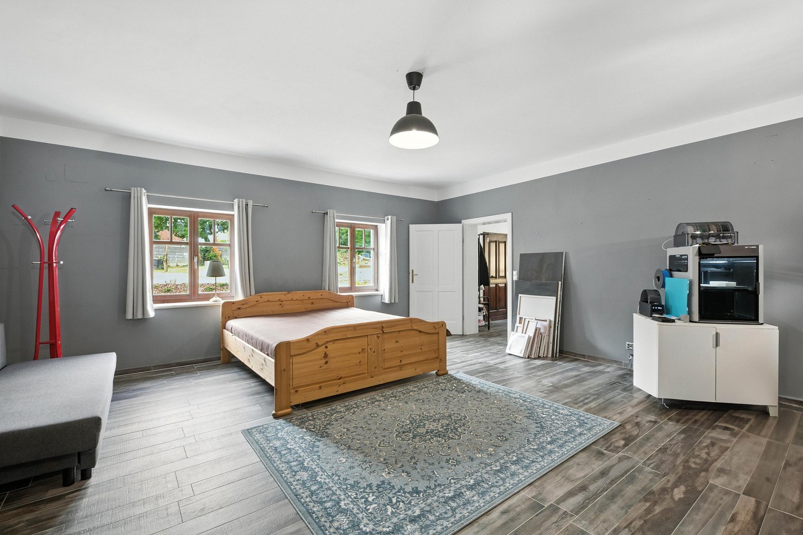 Modern ausgebautes Schlafzimmer mit grauen Wänden und großem Bett